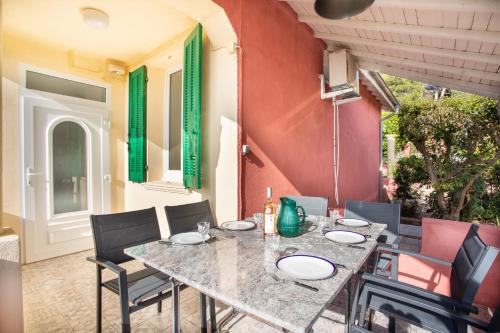 een tafel en stoelen op een patio bij Breathtaking view house with large garden - Dodo et Tartine in Le Pradet
