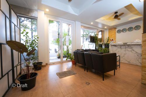 a living room with a bunch of chairs and plants at Beach Breeze and Spa in Hulhumale