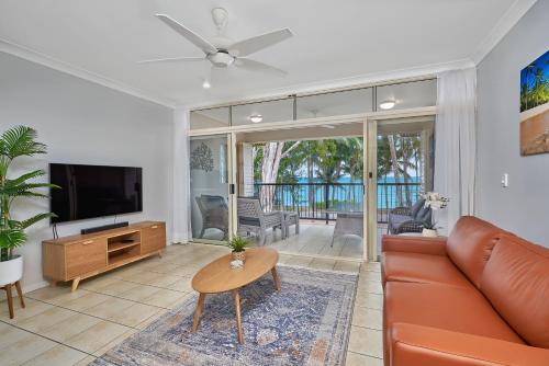 a living room with a couch and a flat screen tv at Coral Views at Clifton Beach in Clifton Beach
