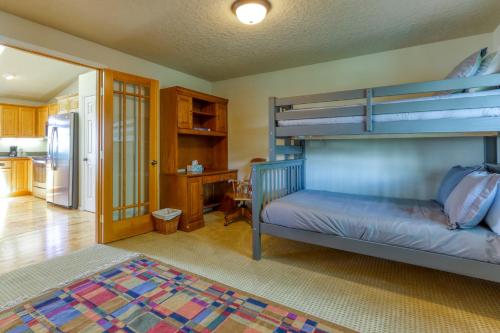 a bedroom with a bunk bed and a kitchen at Meadow Walk Cabin in La Pine