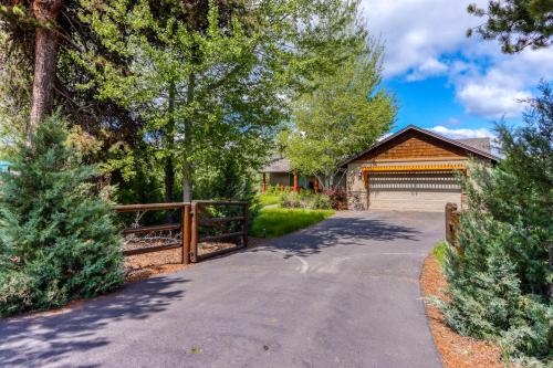 a driveway leading to a house with a fence at Meadow Walk Cabin in La Pine
