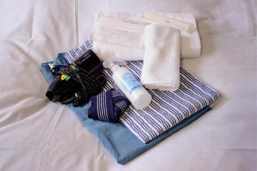 a pile of towels and a toothbrush and a bottle of tooth paste at ホテルスターらんど in Tsuru 