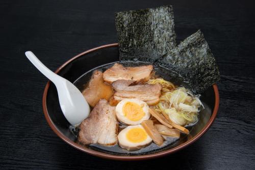 a bowl of food with meat and eggs and a spoon at ホテルスターらんど in Tsuru 