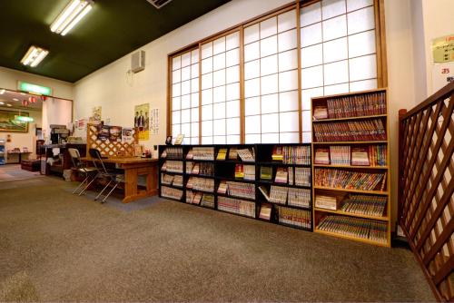 a library with shelves filled with books and a desk at ホテルスターらんど in Tsuru 