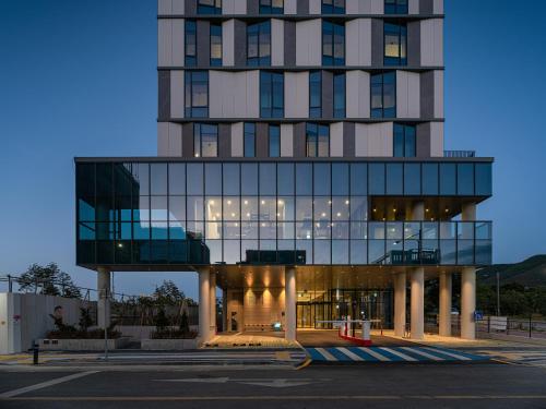 a tall building with a glass facade at Act Tourist Hotel in Daegu