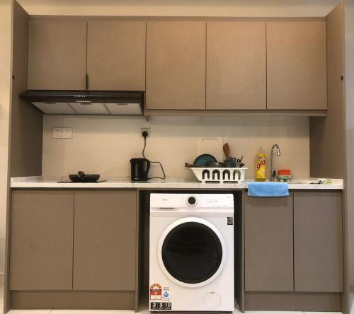 a kitchen with a washing machine on a counter at Lucky Continew Residence 1 Bedroom - TRX KL in Kuala Lumpur