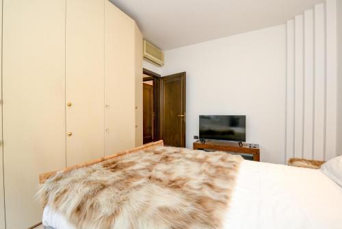 a bedroom with a bed with a fur blanket on it at Prestige Suite Sirmione in Sirmione