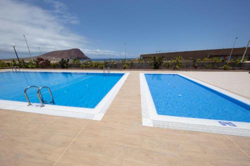 a large swimming pool with blue water in a building at MEDANO4YOU Carpe Diem La Tejita in La Tejita