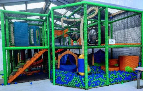 a green cage with toys in it at Three Lochs Holiday Caravan for Families and Couples in Newton Stewart