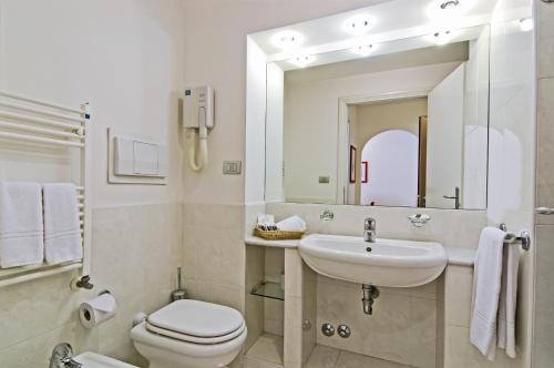 a bathroom with a sink and a toilet and a mirror at Best Western Hotel I Triangoli in Casal Palocco
