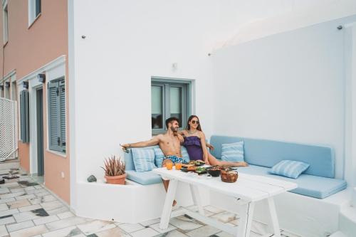a man and woman sitting on a couch on a patio at Oia Captain's Villa in Oia