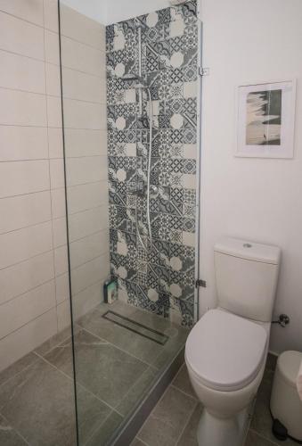 a bathroom with a toilet and a glass shower at Anemomylos guesthouse in Paralimni