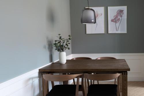 - une table à manger avec des chaises et un vase dans l'établissement Ankerhus Skagen, à Skagen