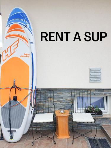 two chairs and a surfboard on the side of a building at Vila Rajska ptica in Bled