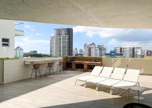 a balcony with chairs and a bar on a building at Escape Apartments, Balcony, Pool, Gym & Spa in La Julia in Santo Domingo