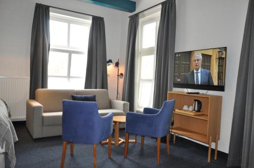 a living room with a tv and a table and chairs at Hohes Haus in Greetsiel
