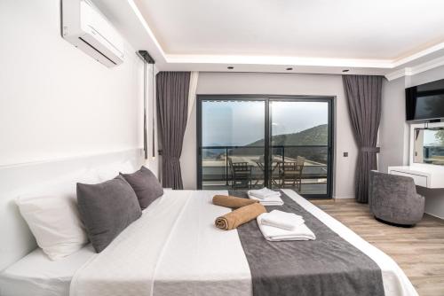 a bedroom with a large white bed and a balcony at Villa Parle in Kalkan