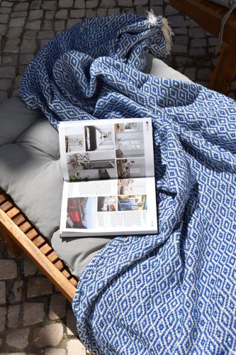 a blanket with a magazine on top of a bed at Beach house upscale villa with pool in Costa da Caparica