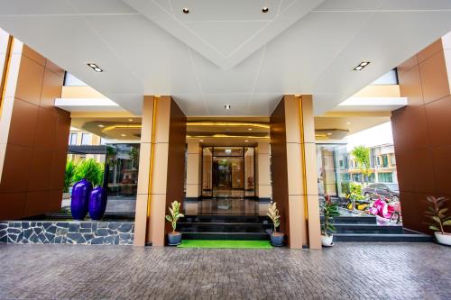 a lobby of a building with potted plants at Siri Hotel Lumphun in Ban Pa Daet