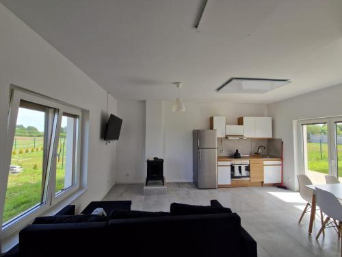a living room with a couch and a kitchen at Z Widokiem na Wydmę in Łokciowe