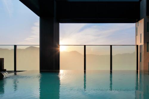 a swimming pool with a view of the mountains at Candeo Hotels Nagasaki Shinchi Chinatown in Nagasaki