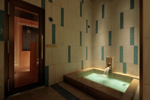 a bathroom with a tub with a water fountain at Candeo Hotels Nagasaki Shinchi Chinatown in Nagasaki