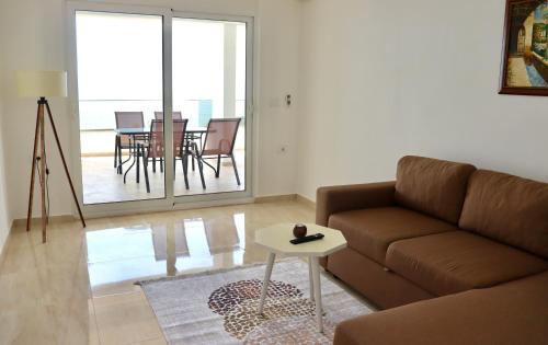 uma sala de estar com um sofá e uma mesa em IdealHouse Apartments em Ulcinj