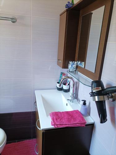 a bathroom with a sink with a pink towel on it at The house in the port in Korissia