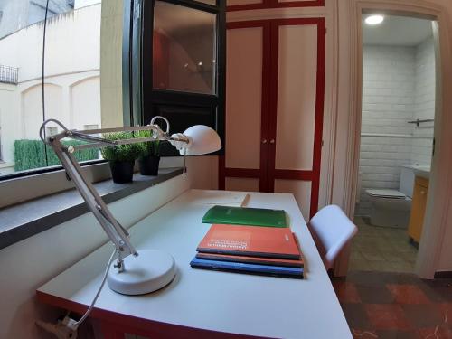 un escritorio con una lámpara y libros. en LoopINN Granada, en Granada