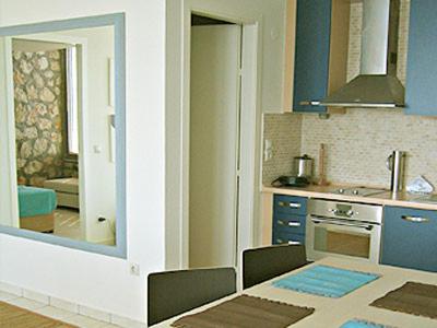 kuchnia z niebieskimi ścianami, stołem i lustrem w obiekcie Villa Brio w mieście Skála Kefalonias