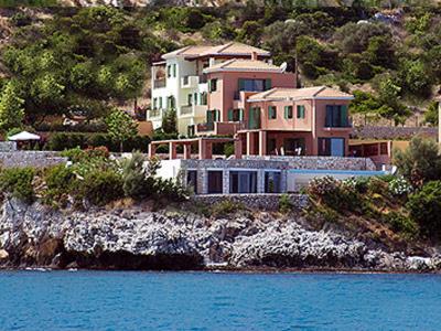 a large house on a hill next to the water at Villa Brio in Skala Kefalonias