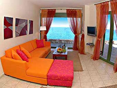 an orange couch in a living room with a view of the ocean at Villa Brio in Skala Kefalonias
