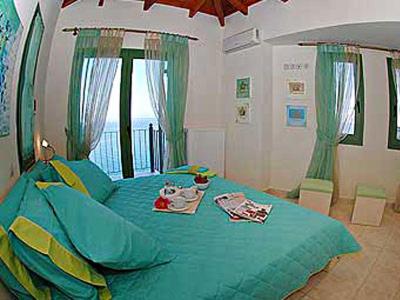 a bedroom with a bed with a blue comforter at Villa Brio in Skala Kefalonias
