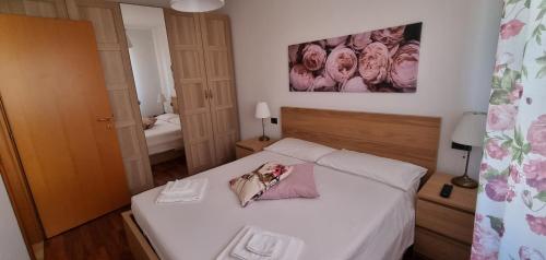a bedroom with a bed with white sheets and flowers on it at stazione - centro Forlì in Forlì