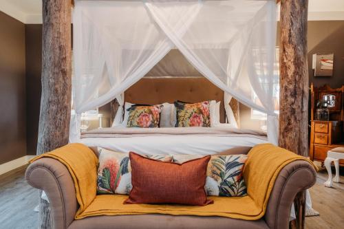 a bedroom with a canopy bed with a couch at White Water Farm in Stanford