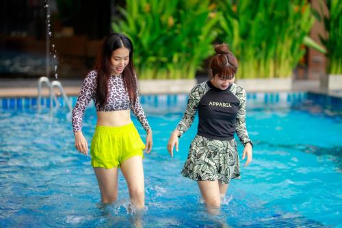 two young girls playing in a swimming pool at Siri Hotel Lumphun in Ban Pa Daet