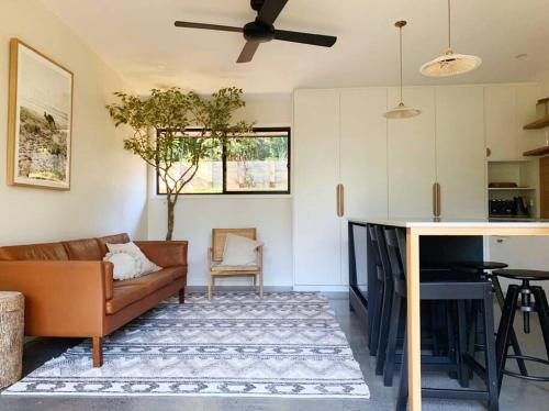 un soggiorno con un divano e un tavolo di The Brook View Byron Bay a Ewingsdale