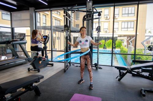 a woman in a gym with a resistance band at Siri Hotel Lumphun in Ban Pa Daet
