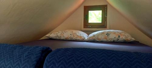 a bedroom with a bed and two pillows in a attic at Krka Magic Pumpkin in Rupe