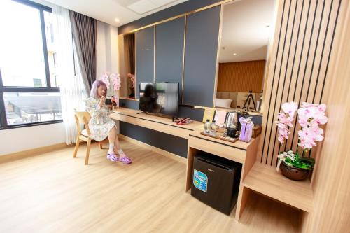 a woman sitting at a desk in a hotel room at Siri Hotel Lumphun in Ban Pa Daet