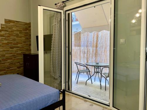 um quarto com uma cama, uma mesa e uma porta de vidro em Cozy LOFT Κypseli with a yard em Atenas