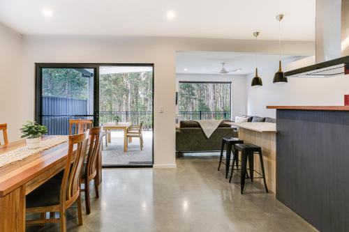a kitchen and dining room with a table and chairs at Karri Forest Vista-peaceful home with forest views in Margaret River Town
