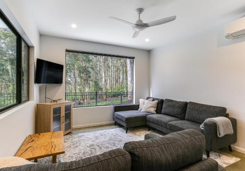 a living room with a couch and a tv at Karri Forest Vista-peaceful home with forest views in Margaret River Town