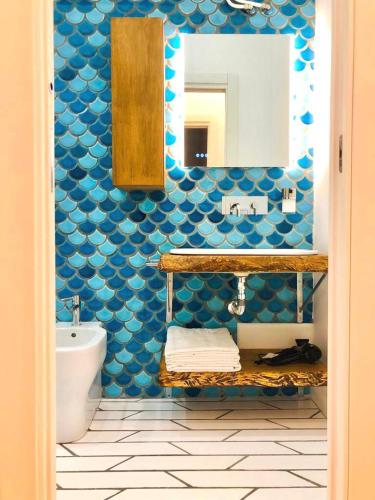 a blue bathroom with a sink and a toilet at B&B Historia in Pozzuoli