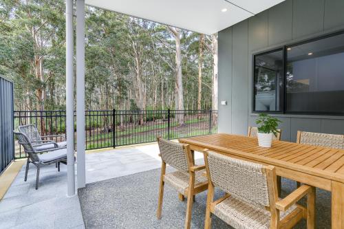 a patio with a wooden table and chairs at Karri Forest Vista-peaceful home with forest views in Margaret River Town