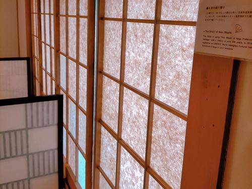 a glass window with snow on it in a room at Saga International Guesthouse Hagakure in Saga