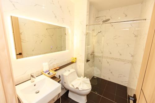 a bathroom with a toilet and a sink and a shower at Siri Hotel Lumphun in Ban Pa Daet