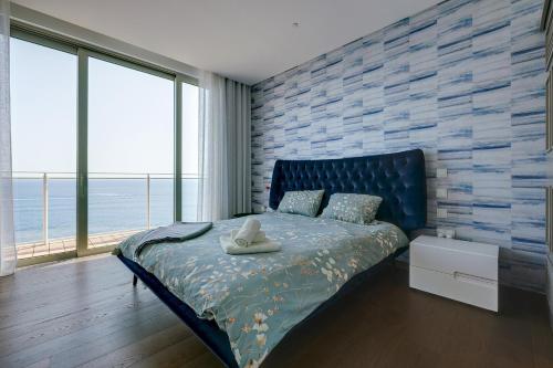 a bedroom with a bed with a blue brick wall at Super Luxury Apartment in Tigne Point, Amazing Sea Views in Sliema