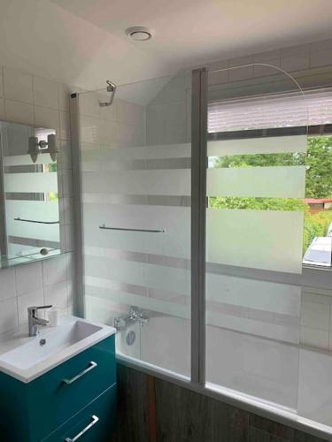 une salle de bain avec un lavabo et un miroir dans l'établissement Maison chaleureuse à proximité de la mer, à Sainte-Marguerite