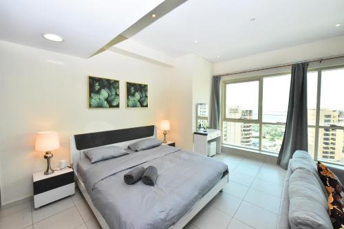 a bedroom with a large bed and a couch at Furnished studio with balcony in Marina -JMI in Dubai